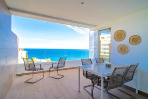 a dining room with a table and chairs and the ocean at Luxury Rooftop Isea 1132 by Casasol in Torrox Costa
