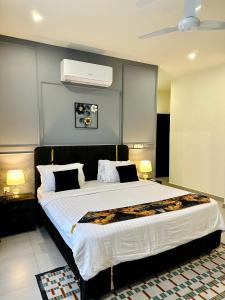 a bedroom with a large bed with white sheets and pillows at 2 BHK Apartment in ISLAMABAD in Islamabad