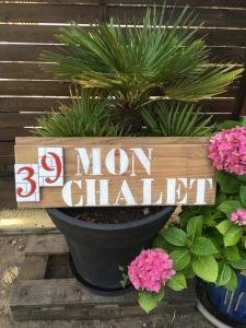 a sign for a garden with a plant in a pot at Mon chalet in Le Teich