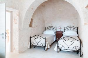 Postel nebo postele na pokoji v ubytování Apulian Charme Trulli and Cottage