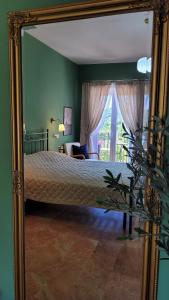 a mirror reflecting a bedroom with a bed and a window at Villa MaVi Guesthouse in Maenza