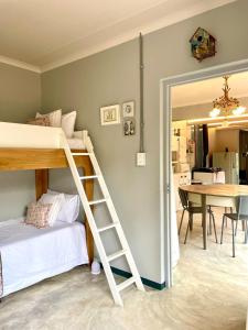 a bedroom with a bunk bed and a table at Underberg - The Burn - Solar Powered in Underberg