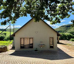 a small white building with a statue in the window at Underberg - The Burn - Solar Powered in Underberg