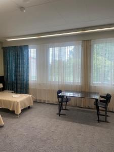 a room with a table and chairs and windows at Hotel Ilomantsi North Star in Ilomantsi +146 photos