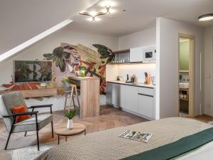 a kitchen and living room with a large painting on the wall at The Botanist by Adrez in Prague