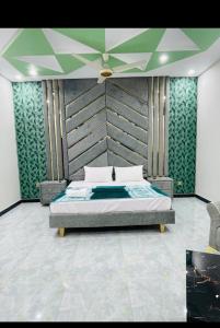 a bedroom with a bed with a large headboard at Ayan stay inn in Dargai