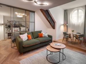 a living room with a green couch and a table at The Botanist by Adrez in Prague