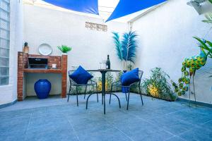 a patio with a table with blue chairs at Amshiga 4 in Jimbaran