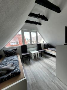 フィリンゲン・シュヴェニンゲンにあるFischer Apartment 2 - geräumige Monteurs- & Ferienwohnung mit 4 Schlafzimmern - neu renoviert mit privater Terrasse, Smart-TV & voll ausgestatteter Küche - ideal für Arbeit, Gruppen & Familienのベッドルーム1室(ベッド1台、椅子2脚、テーブル付)