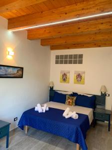 a bedroom with a bed with blue sheets and wooden ceilings at U muragghiuni n3 in Lascari