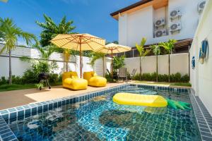 una piscina con sombrilla e inflable en Kamala Sunshine Villa - Goldena Twin, en Kamala Beach