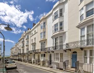 a row of white buildings on a city street at Beautiful Central Brighton l Sea View I Spacious Studio Flat I Sleep 2-3 Guests in Brighton & Hove
