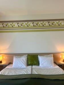 a bedroom with a large bed with two pillows at Kisfaludy Kásté in Dobronhegy +6 photos
