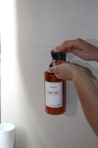a person holding a bottle of liquid on a wall at Appartamento in Centro Living Pescara in Pescara
