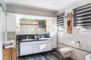 a bathroom with two sinks and a toilet at Wia Dahoam Appartement in Völs +48 photos
