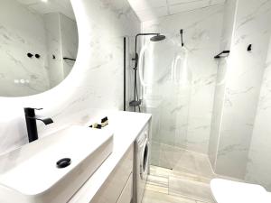 a white bathroom with a sink and a shower at iloftmalaga Ático Pozos Dulces in Málaga +23 photos
