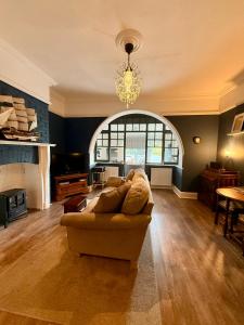 a living room with a couch and a chandelier at Luxury Garden Flat by the Sea, Captains Quarters in Sheringham