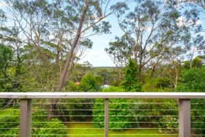 a view from a porch with a fence and trees at Godfrey's Cottage in Blackheath +4 photos