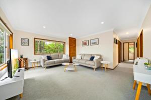 een woonkamer met twee banken en een tv bij Godfrey's Cottage in Blackheath