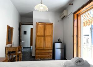 a room with a bed and a refrigerator and a window at Lenitsa Central Parga Rooms in Parga