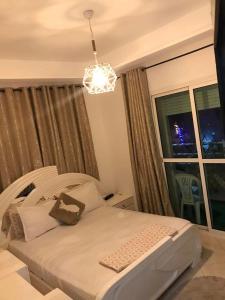 a bedroom with a bed and a window with a chandelier at Salam Beach in Pont Blondin +9 photos