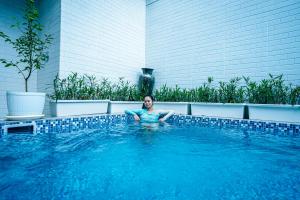 a woman is sitting in a swimming pool at Amshiga 5 in Jimbaran