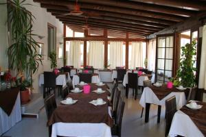 a dining room with tables and chairs and windows at Albergo Al Pescatore in Brenzone sul Garda