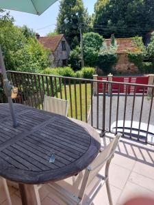 un tavolo e sedie in legno su una terrazza con ombrellone di Maison à la campagne a Beyssac Altre 4 foto