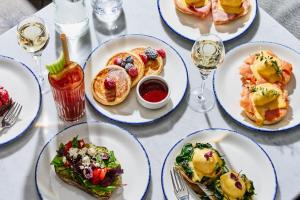 een tafel met borden met eten en glazen wijn bij INK Hotel Amsterdam - MGallery Collection in Amsterdam