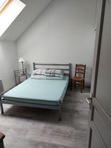 una camera con un letto, una sedia e una porta di Maison à la campagne a Beyssac