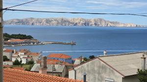 a view of a town with the ocean and mountains at LOVELY APARTMENTS Senj - Spectacular Sea View & Free Parking & WI-FI in Senj