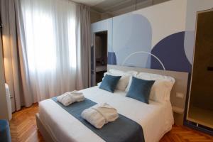 a bedroom with a large white bed with blue pillows at B&B Villa Margherita - Luxury Rooms in Padua in Padova
