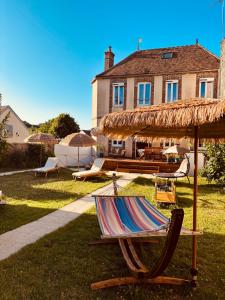 a lawn with a chair and a umbrella and a house at Villa Fontaine avec piscine intérieur chauffée-Maison de campagne Familiale -idéal Vacances ou Séjour Professionnel -3 chambres-Bureau séparé -Lit Bébé - Parking Facile & Gratuit in Fontaine-la-Gaillarde