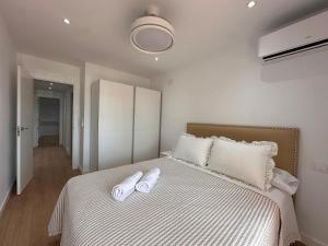 a bedroom with a bed with two white towels on it at A&N Seafront 2 Torre del Mar in Torre del Mar