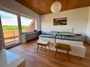 a bedroom with a large bed and a large window at Ferienhaus an der Niers in Weeze