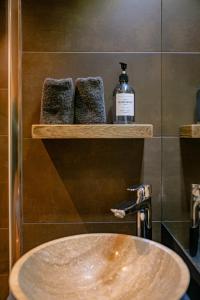 a bathroom with a sink and a bottle of soap at Arly in Megève