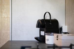 una borsa appoggiata su un tavolo accanto a una macchina per il caffè di La Mèison de la Louye ad Aosta