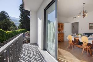 una stanza con balcone con tavolo e sedie di La Mèison de la Louye ad Aosta