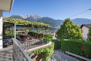 balcone con sedie e tavolo con montagne sullo sfondo di La Mèison de la Louye ad Aosta