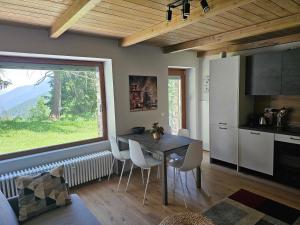 une cuisine et une salle à manger avec une table et une fenêtre dans l'établissement Moda Apartments G5, à Sestrières