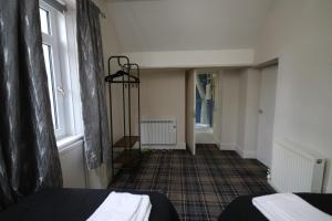a room with two beds and a hallway with a window at Stag View, River Black Water Holiday Flats, INCHBAE, GARVE, IV232PG in Garve +52 photos
