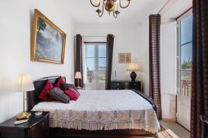 une chambre avec un lit avec des oreillers rouges et une fenêtre dans l'établissement Estoi Heritage, à Estói