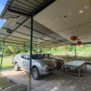 a car parked under a tent with a table and two cars at Kinabalu Poring Vacation Lodge in Kampung Poring +13 photos