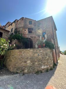 un antico edificio in pietra con un muro di pietra di Casa La Torre a Terricciola