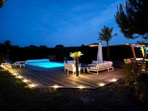 a deck with a table and chairs and a swimming pool at Arès, Villa Mapouchet, piscine in Arès