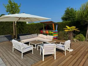 a patio with a table and chairs and an umbrella at Arès, Villa Mapouchet, piscine in Arès