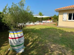 a striped cone sitting in the grass in a yard at Arès, Villa Mapouchet, piscine in Arès