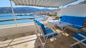 a balcony with a table and chairs and a view of the water at Amasing view from the White terrase in Baška