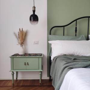 a bedroom with a green end table with a bed at Nine and Three Quarters Rooms in Bologna