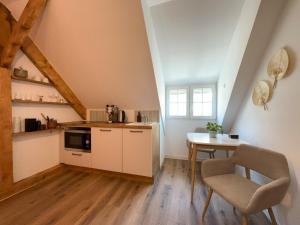a small kitchen with a table and a chair at Cosy sous les toits - Charme et modernité in Sarreguemines